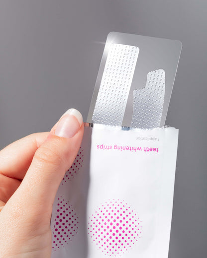 hand holding teeth whitening strips 